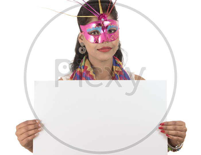An Young Indian Girl Wearing Carnival Mask and Holding White Board or Placard