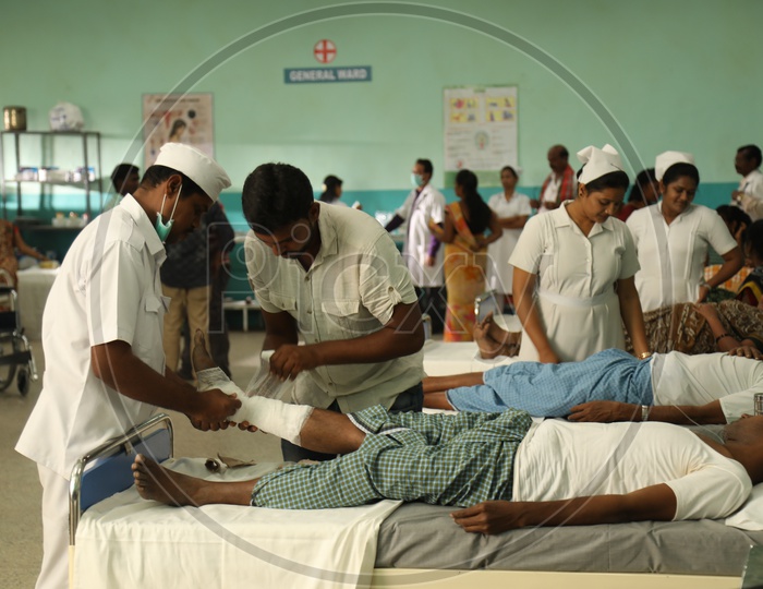 Nurses Treating Patients In A Hospital Ward