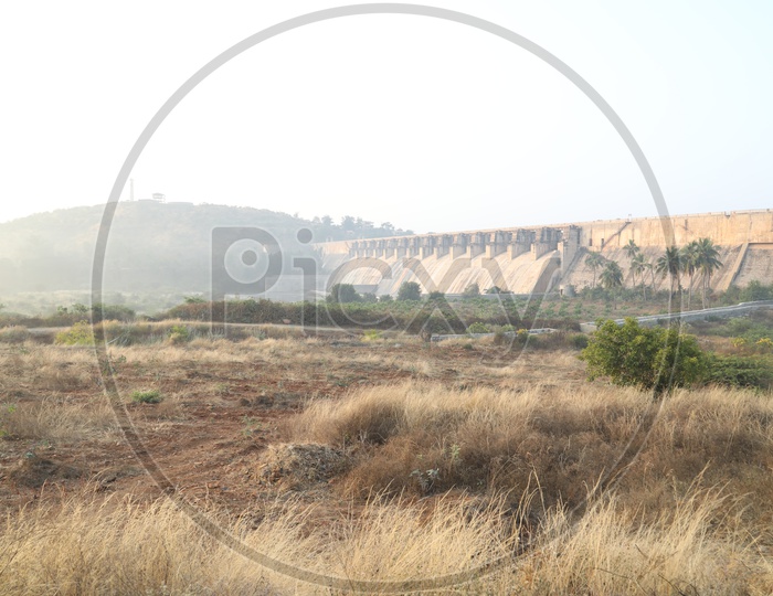 Barren land with water dam in background