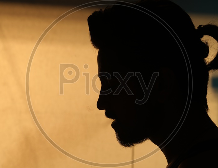 Silhouette Of A Man Over a Golden light Background