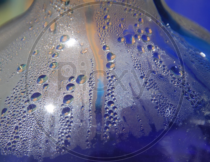 Water droplets inside a glass blue abstract background