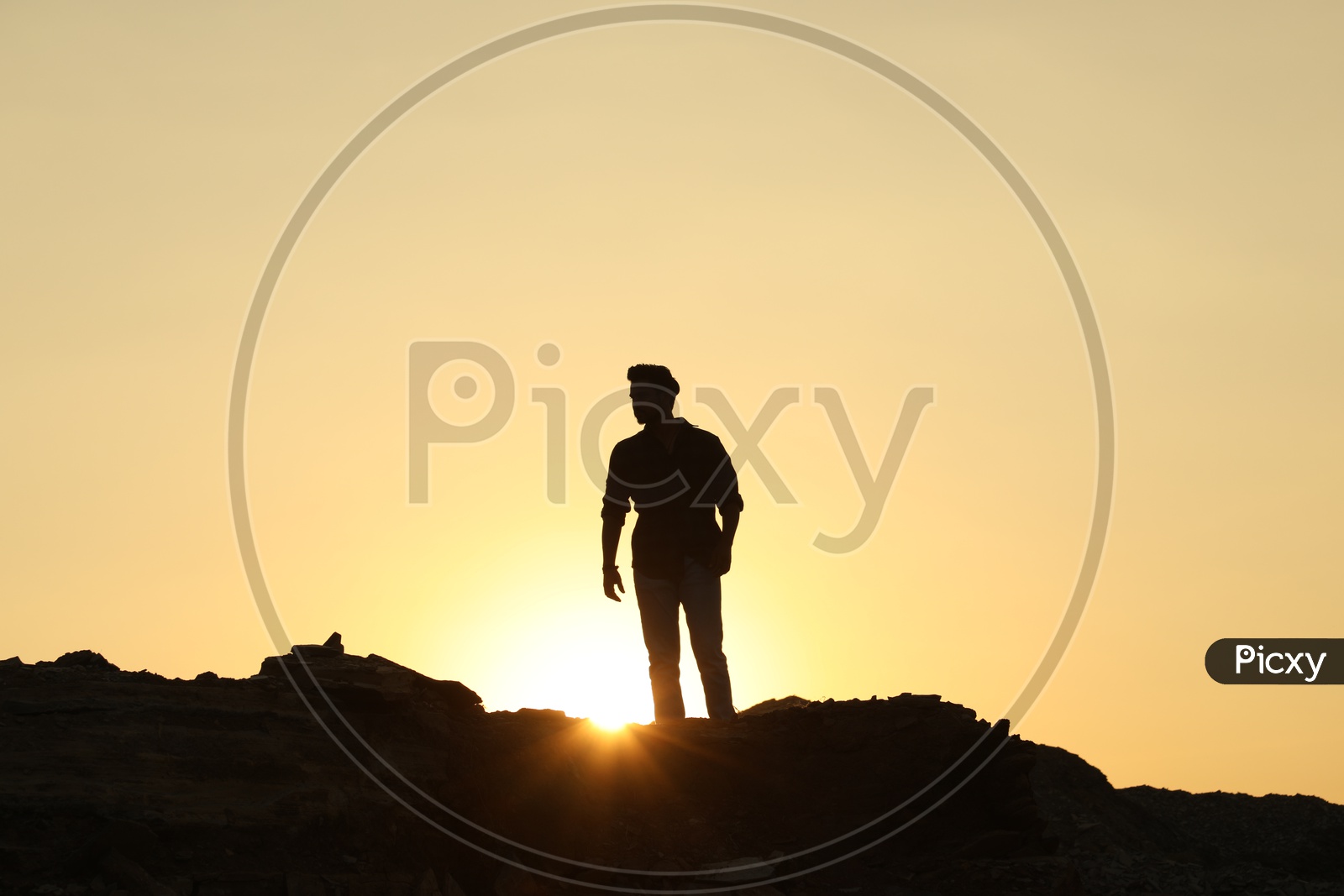 Silhouette of man on the top of the rocky hill