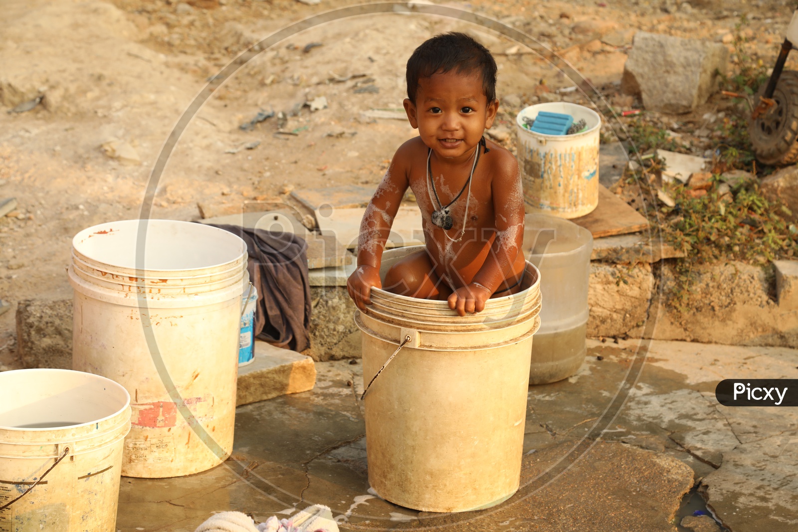 A smiling boy in a bucket