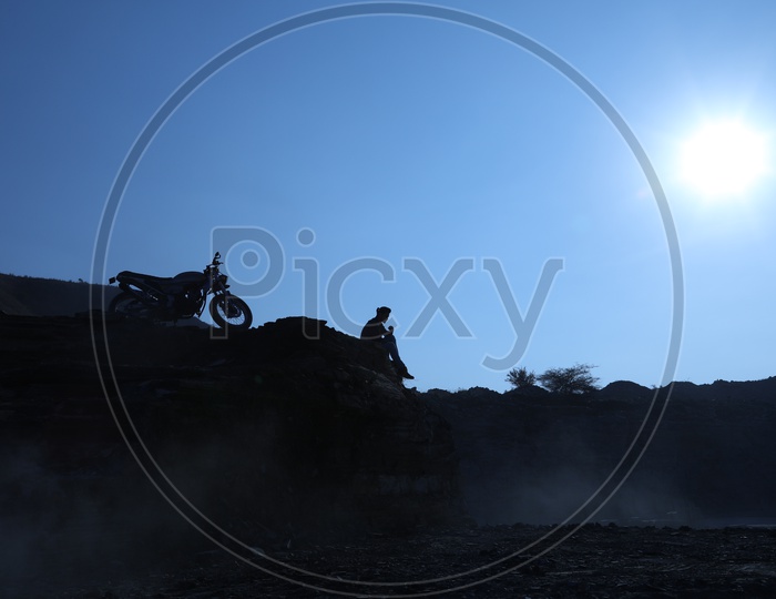 Silhouette of a man with the bike at Black stone mining area