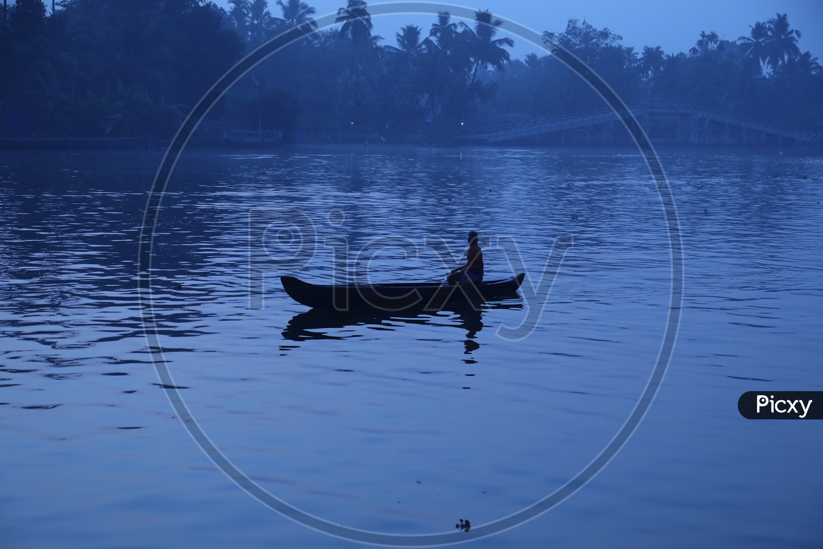 Silhouette Of a Fisher Man In a  Boat In Blue hour  Light