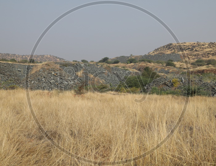 Long view of the black stone mining area from dry steep grass