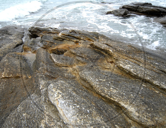Waves Touching The Rocks In a Beach