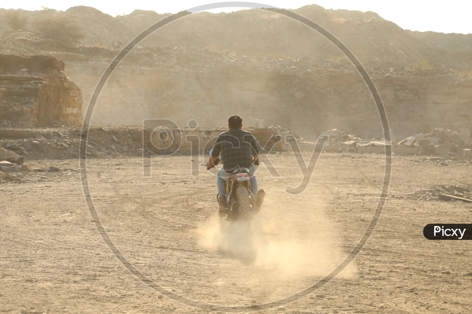 A man riding a bike in a barren land
