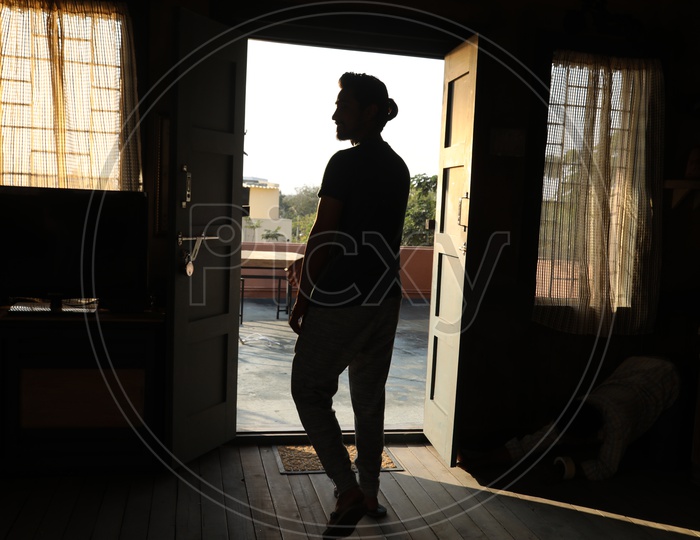 Silhouette Of a man Standing At Door Entrance