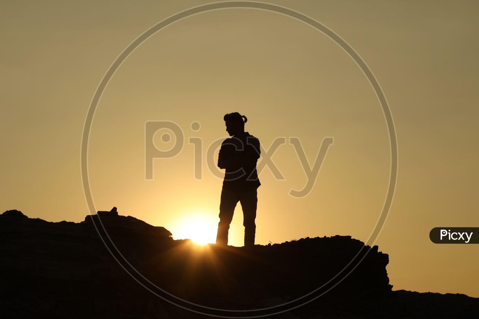 Silhouette of a man on top of the rocky hill
