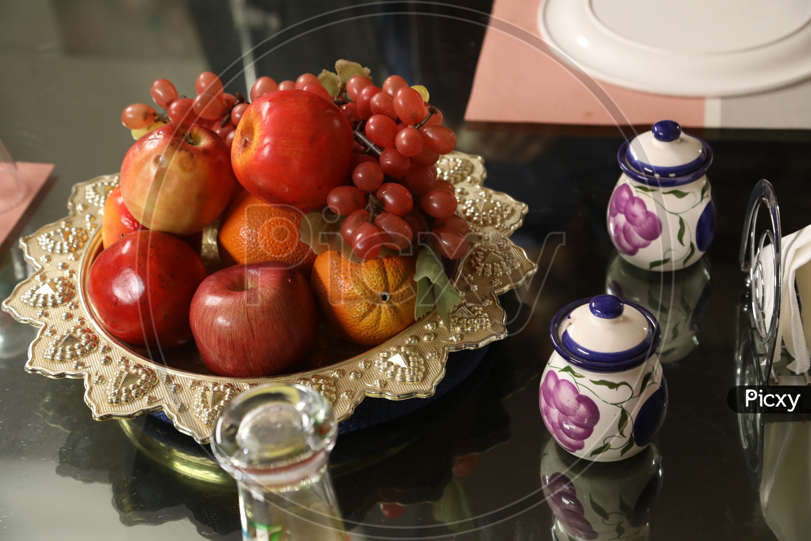 Artificial fruits and jars on dining table