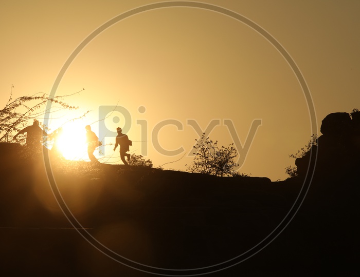 Silhouette of people running on hill