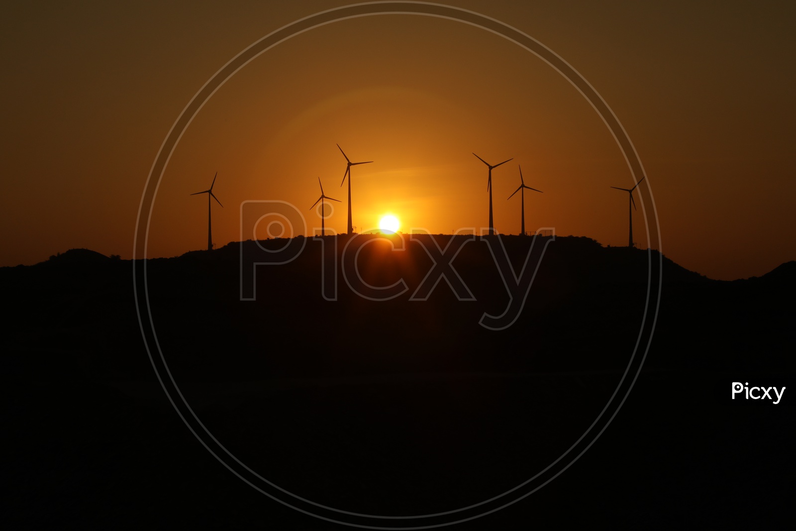Windmills and sunset in the background