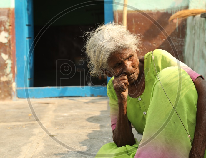 Indian old woman with her thumb inside the mouth
