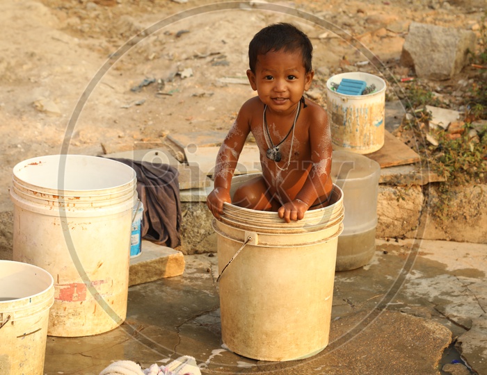 A smiling boy in a bucket