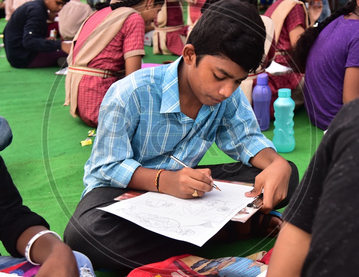 A school kid drawing a sketch during a competition