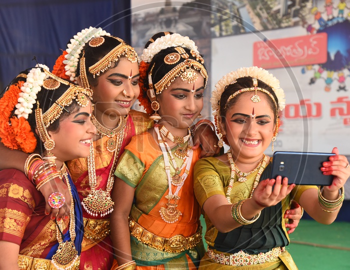 cute little classical dancers taking selfie with mobile
