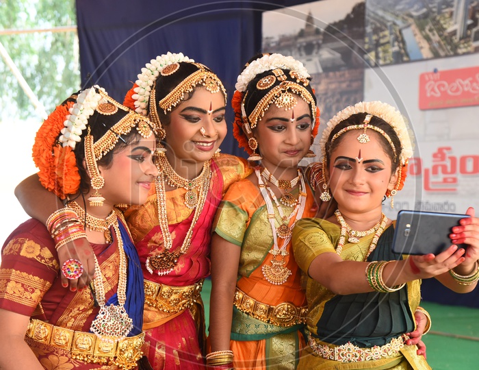 cute little classical dancers taking selfie with mobile