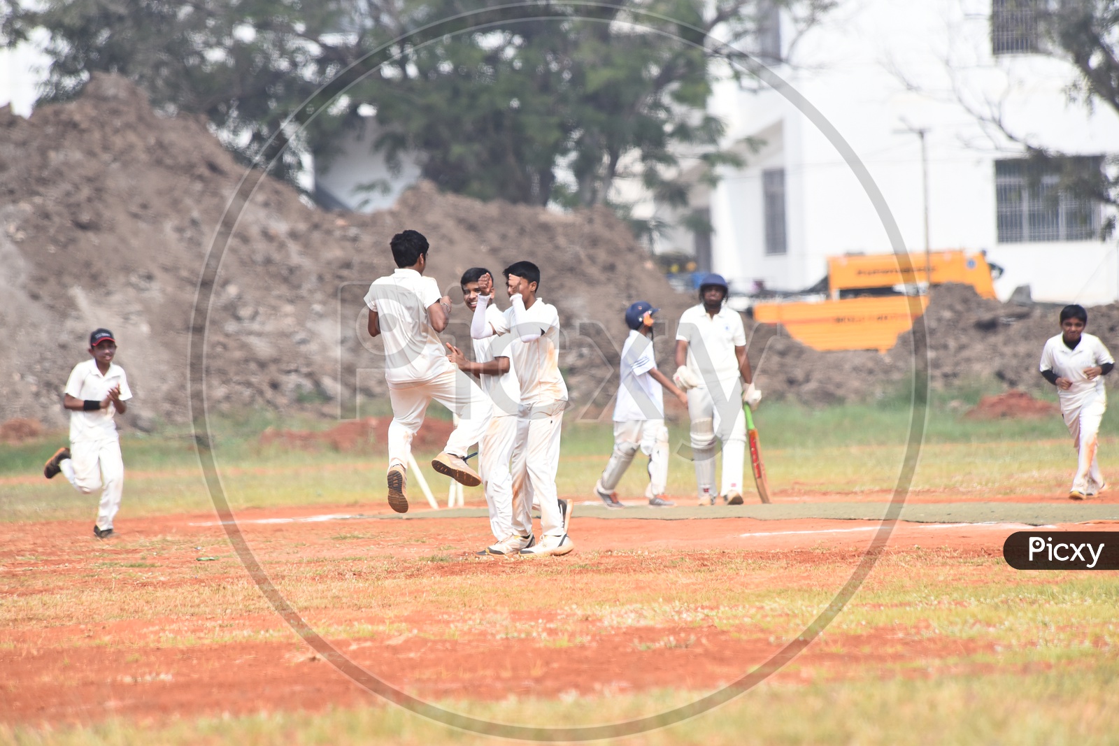 School cricket players celebrating after the fall of wicket