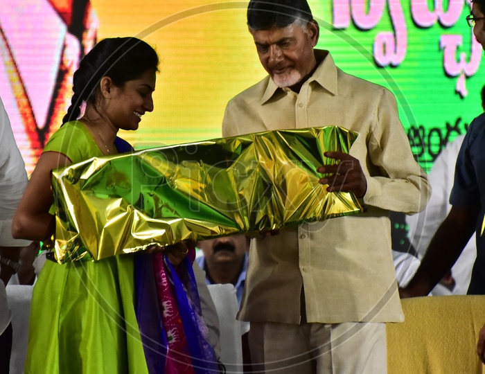 A girl presenting gift article to Chandra Babu Naidu during the launch of Swachh Andhra Mission