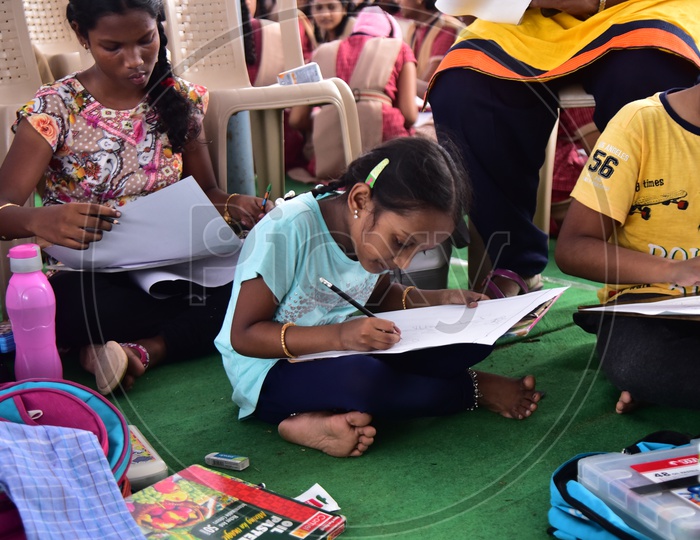 A school girl drawing a sketch of Mahatma Gandhi during competition