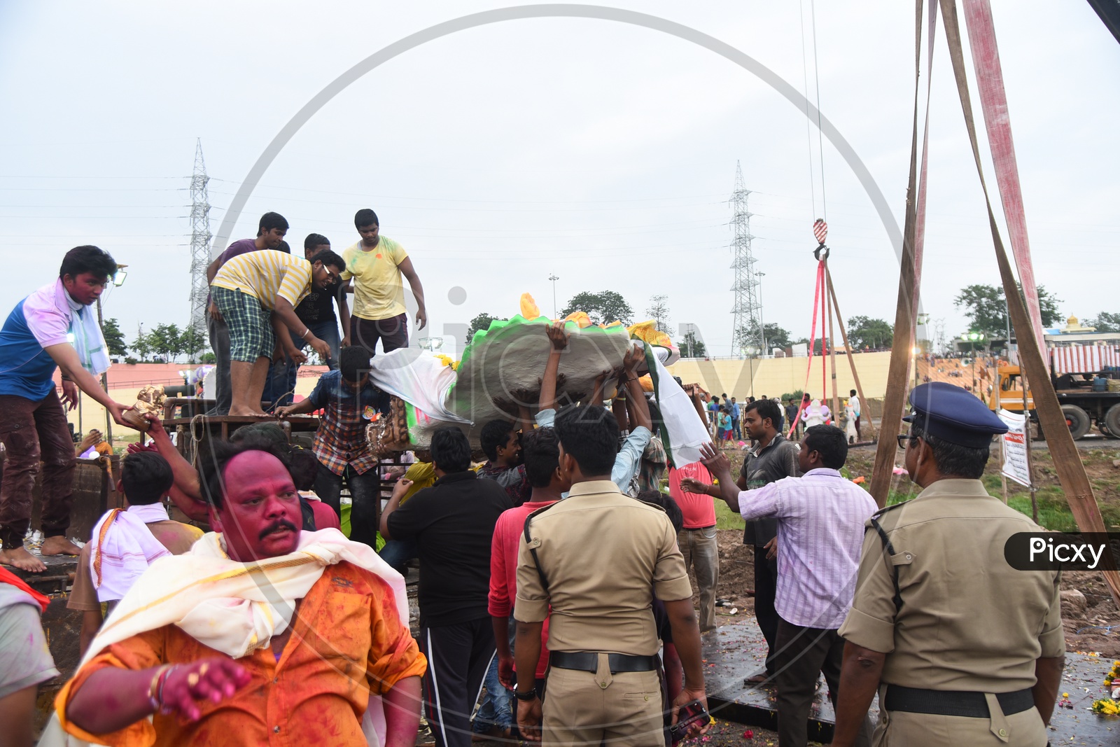 Men carrying the Ganesha idol for visarjan alongside the police men