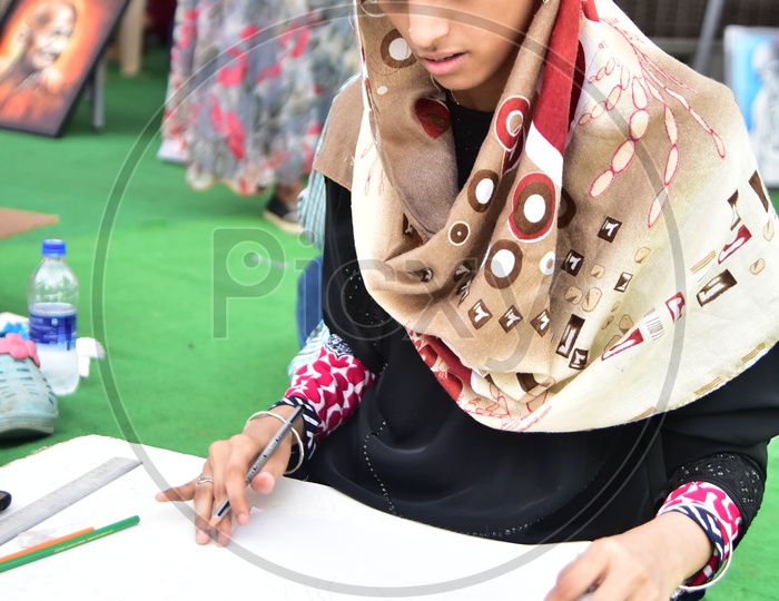 Muslim girl drawing a sketch during competition