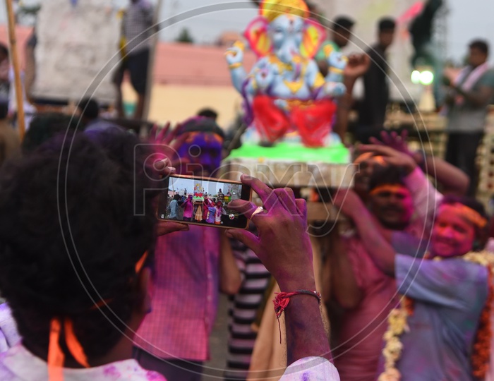 Man taking a picture of Ganesha Idol during the Ganesh Visarjan
