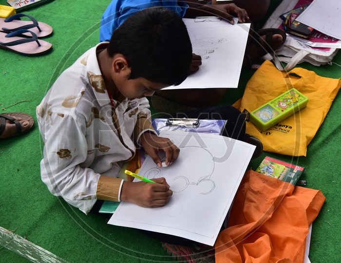 A school boy drawing a sketch of Mahatma Gandhi during a competition