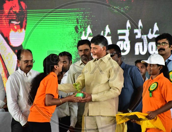 Girls distributing plants to AP Chief Minister Chandra Babu Naidu during the launch of Swachh Andhra Mission