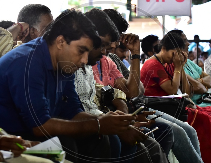 People using smartphones during the launch of Swachh Andhra Mission