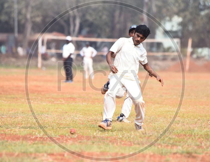 A school kid fielding the ball during a cricket match