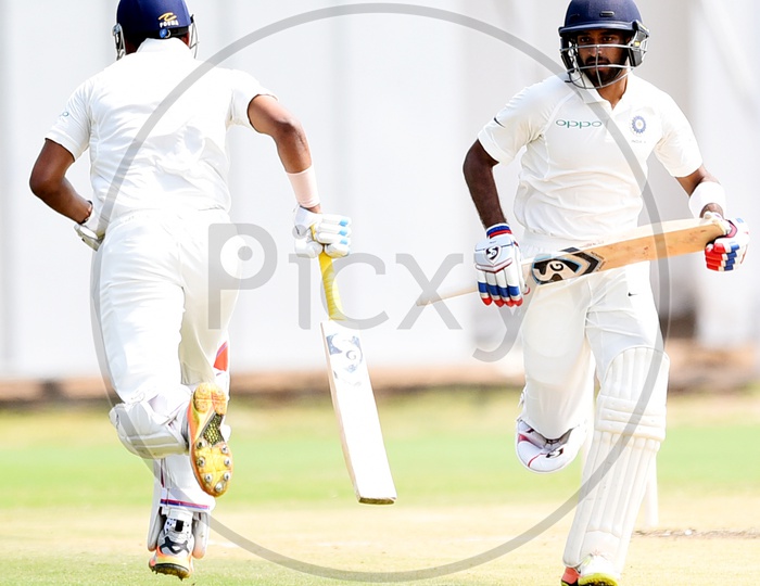 Image of Fielder rubbing the cricket ball over his pantPT327449Picxy