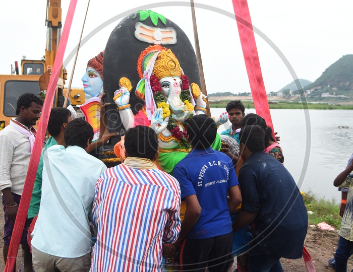 People helping the Ganesha Idol to put on the crane