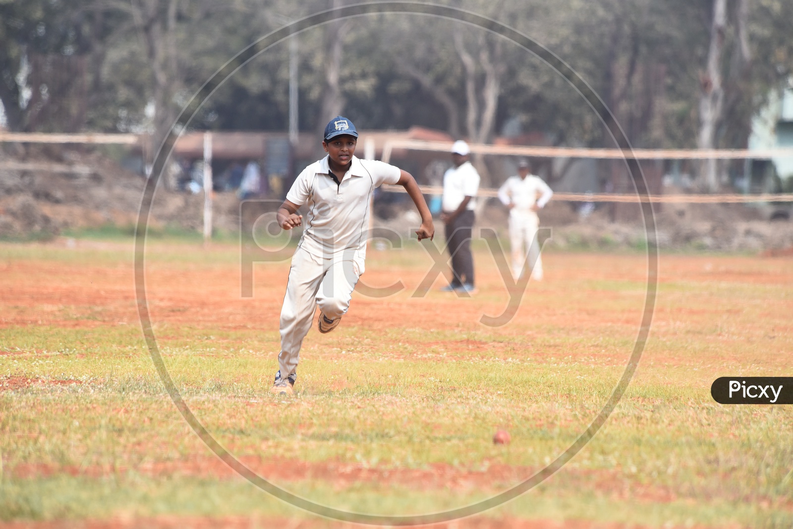 A school kid fielding the ball during a cricket match