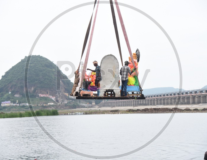 Lord Ganesha Idol being immersed in River Krishna with the help of a crane