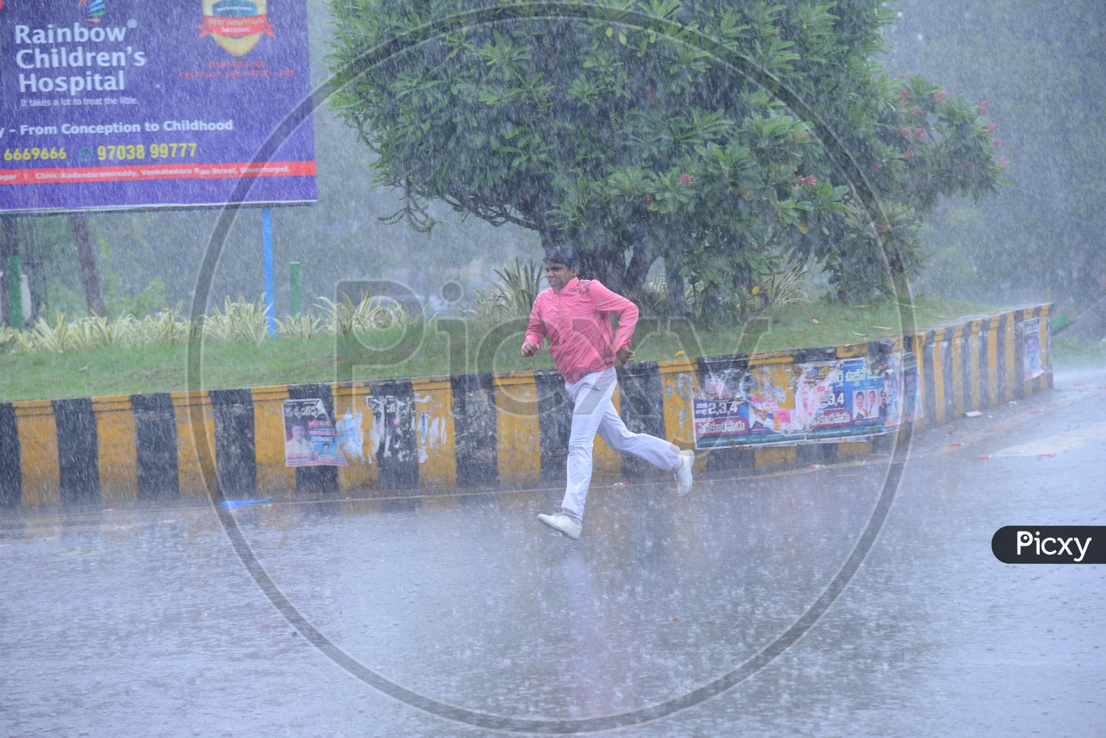 A man running on the road while its raining