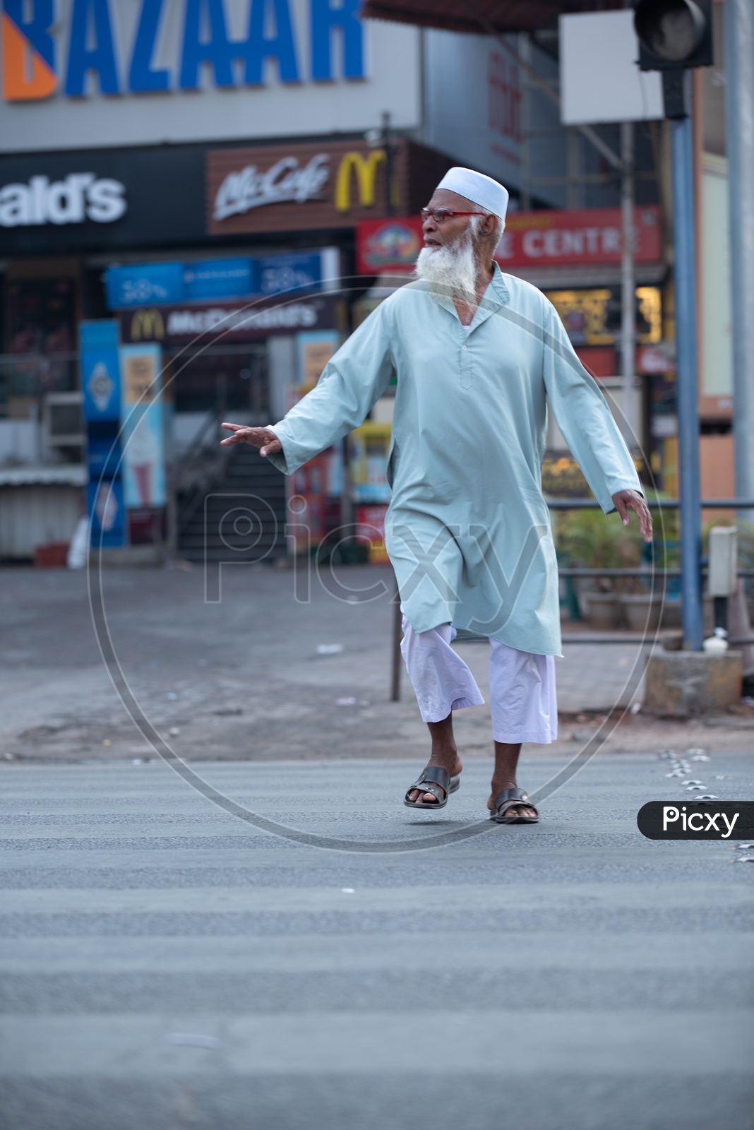 An Old Muslim Man Crossing The Road