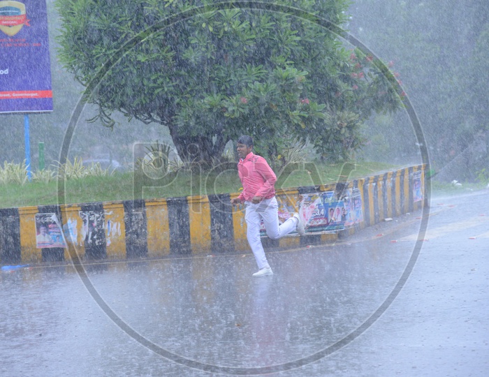 A man running on the road while its raining