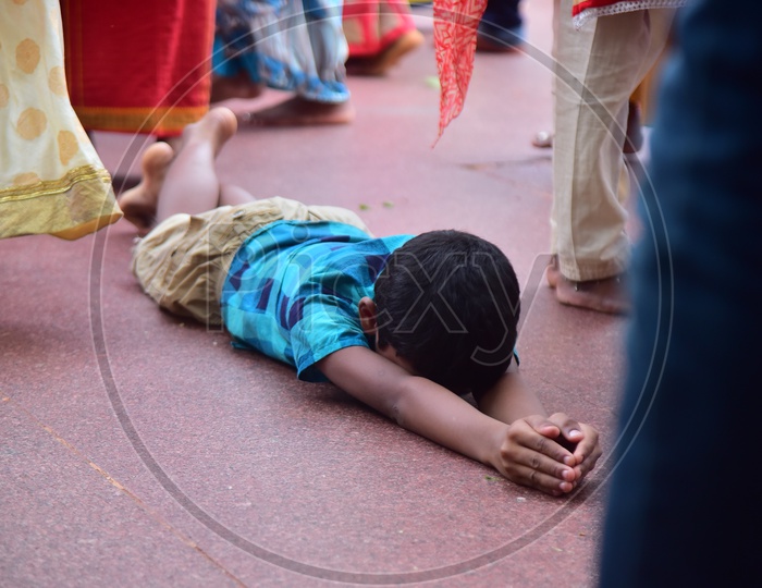 A Boy Devotees Praying on Lying On Floor at Temple