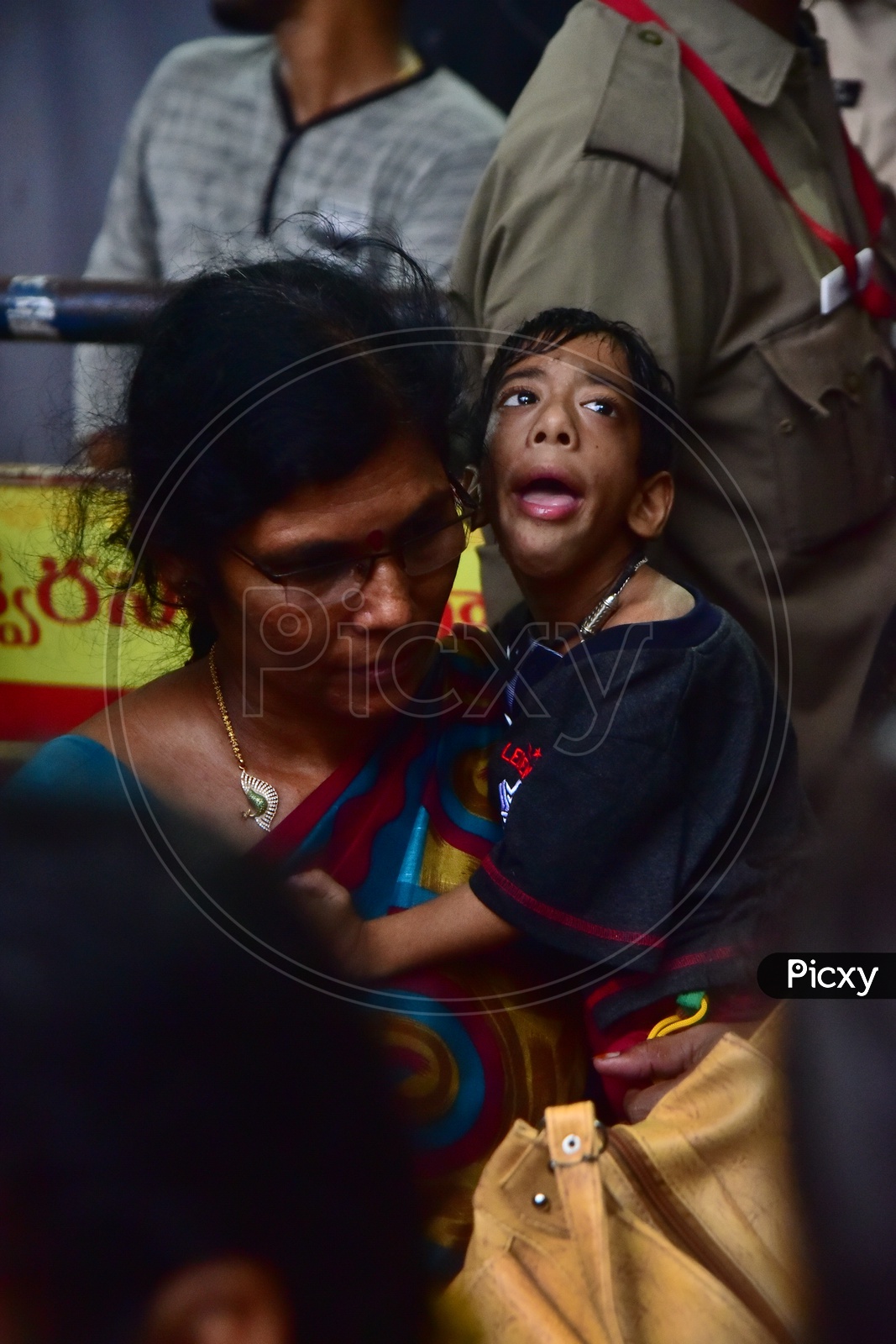 Mother Carrying Her Differently Abled  Child  For Darshan