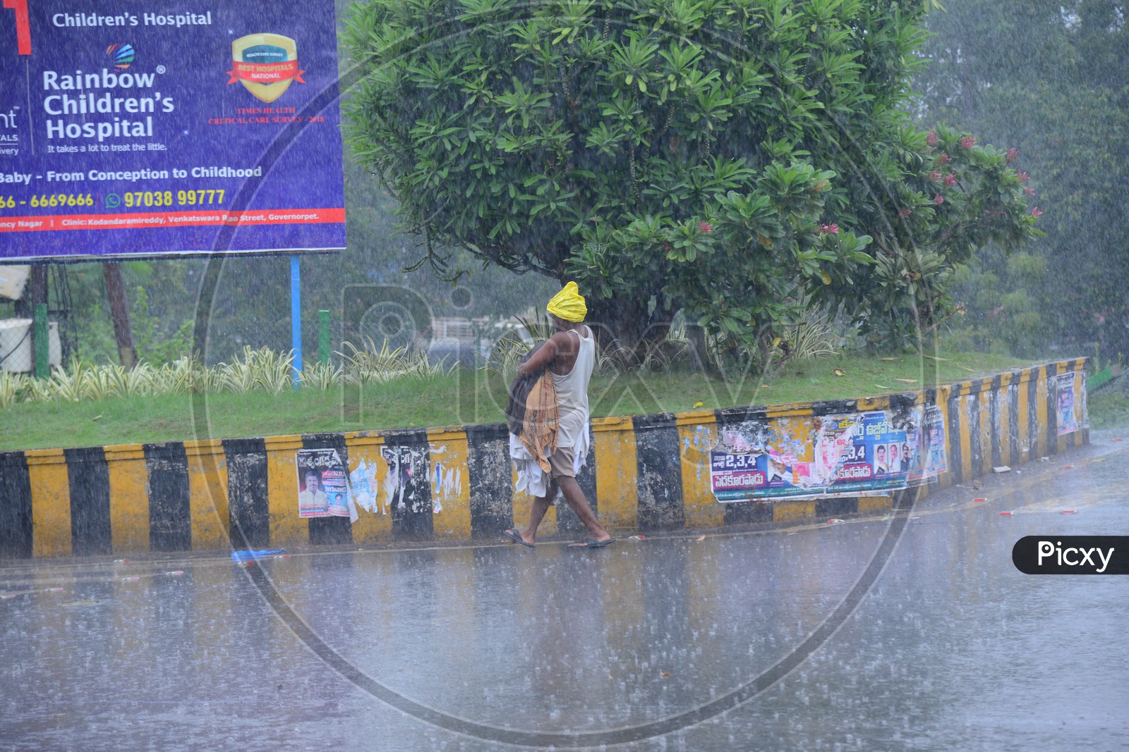 A man walking on the road while its raining