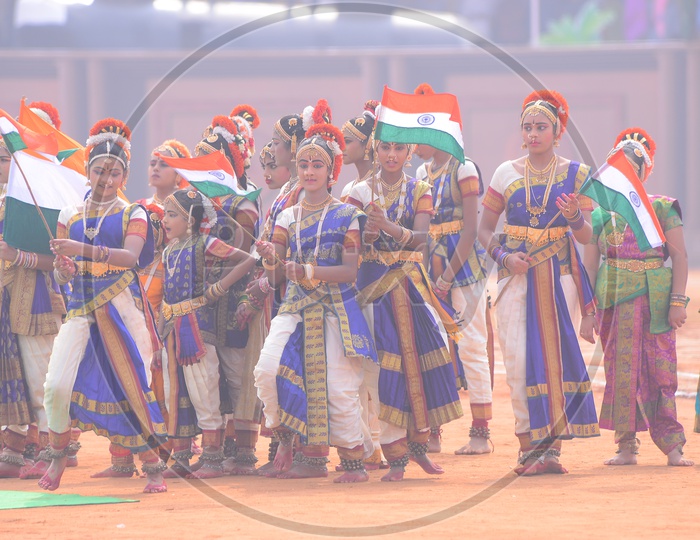 School Students In Classical Dancers Attire Holding Indian National Flags