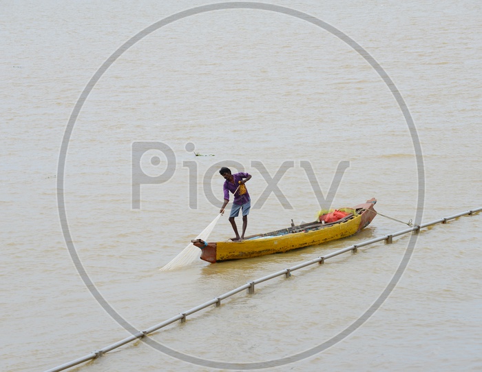 Fisherman with a net standing in the Canoes - Krishna River