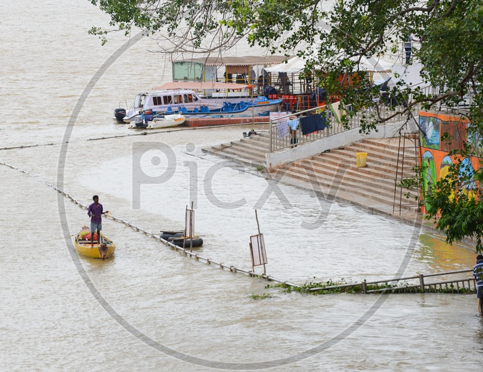 Fisherman with a net standing in the Canoes on the banks of Krishna River