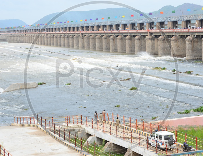 Long view of Praksam barrage with Police men and their Vehicle on the banks of the river Krishna