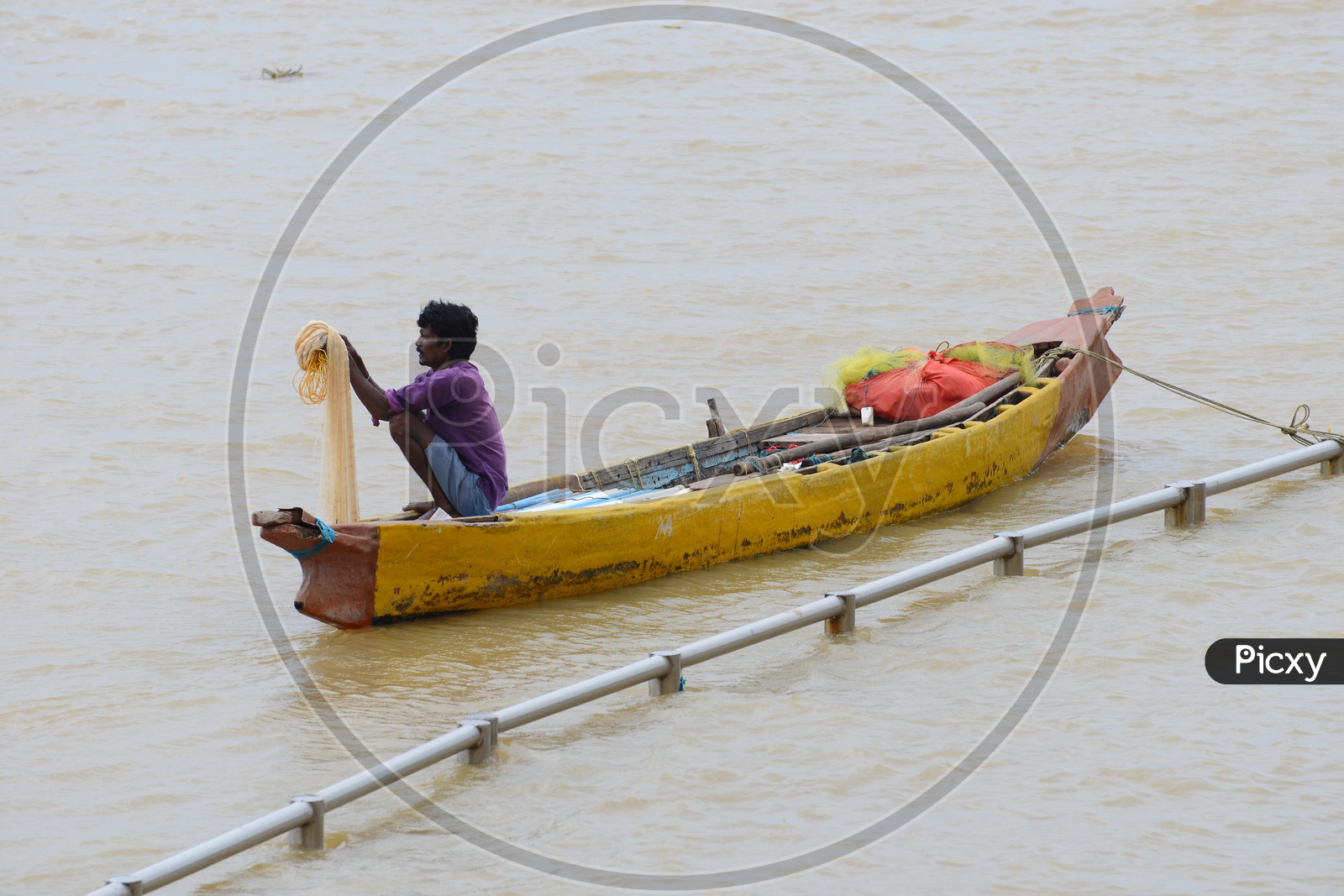 Fisherman with a net sitting in the Canoes - Krishna River