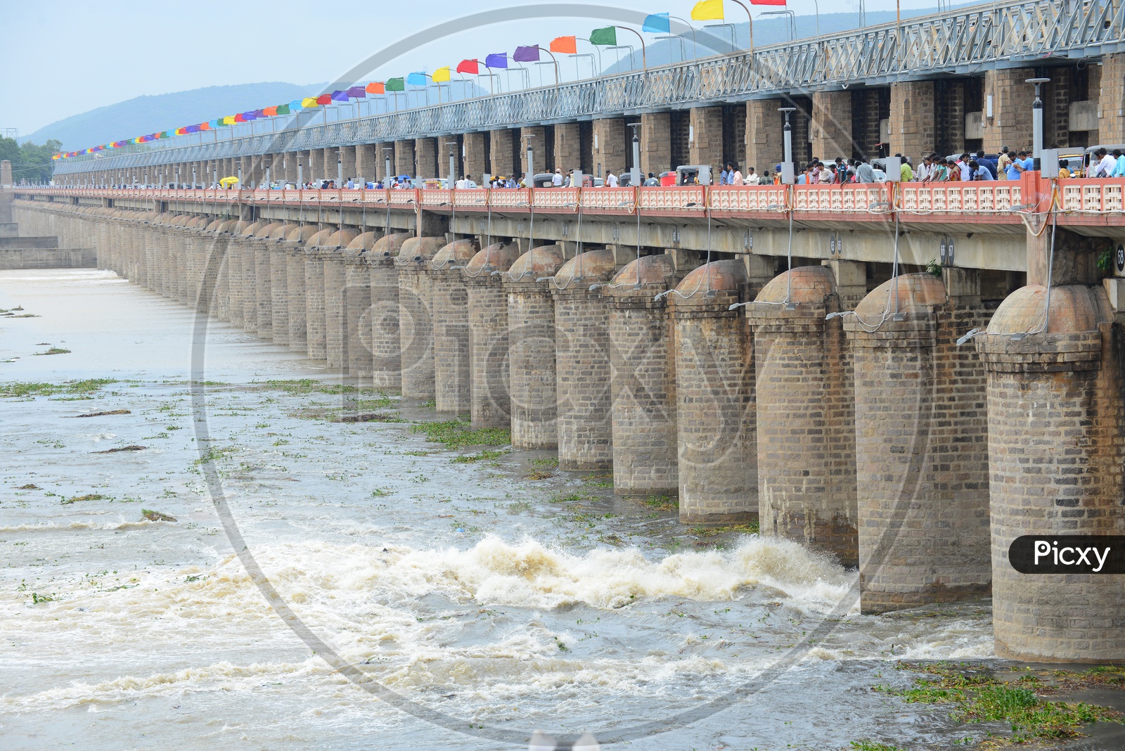 People and traffic on Prakasam barrage over Krishna river in Vijayawada. Gates opened/lifted.