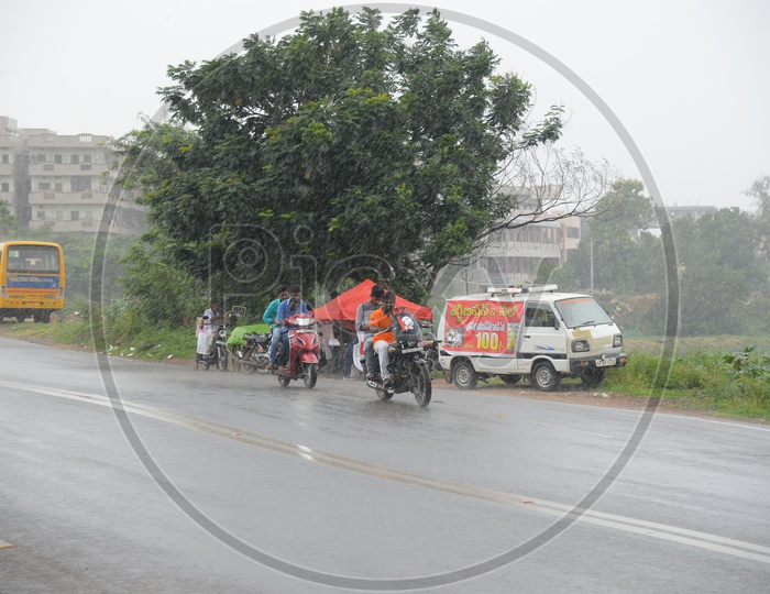 Men riding bikes on road on a rainy day