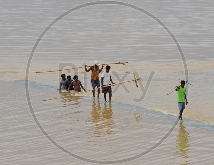 Men with wooden surf fishing rod in Krishna river